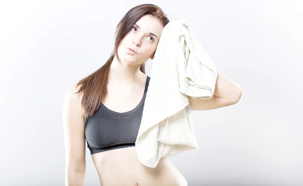 Erschöpfte Frau wischt nach Training Gesicht mit Handtuch ab — Stockfoto