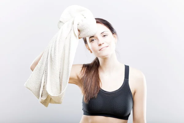 Smiling exhausted young woman after training with towel — Stock Photo, Image