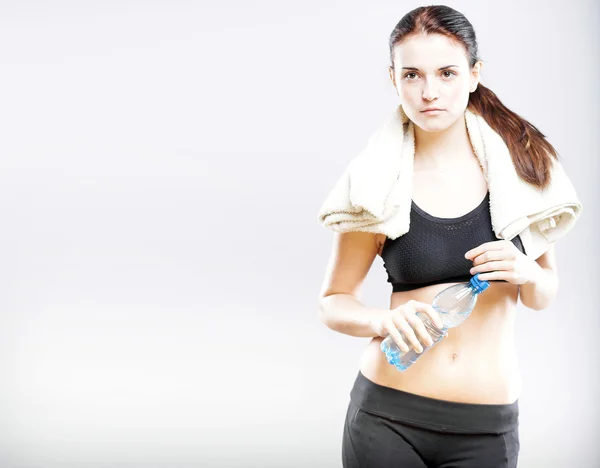 Tired woman after fitness with water bottle and towel — Stock Photo, Image
