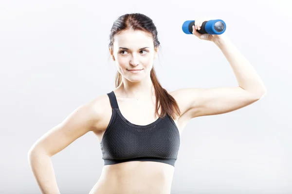 Young fit woman in sport bra during exercise with dumbbells — Stock Photo, Image