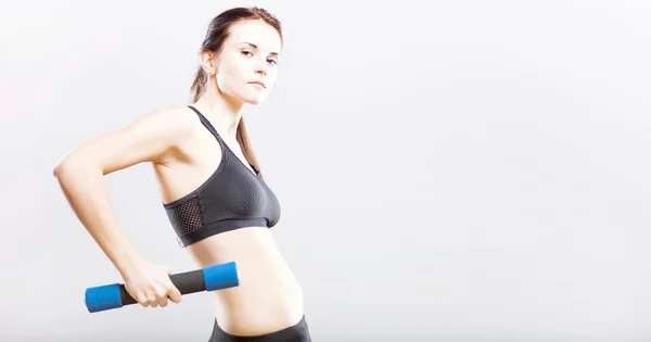 Young fit woman in sport bra during exercise with dumbbells — Stock Photo, Image