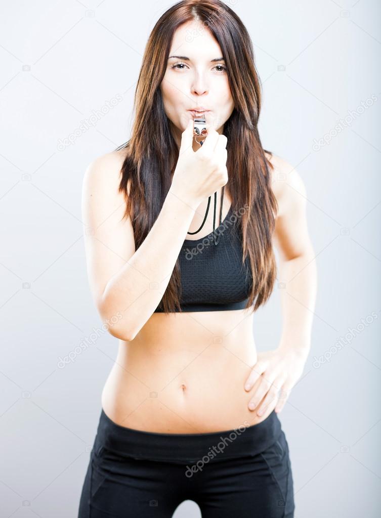 Athletic fitness trainer woman with whistle