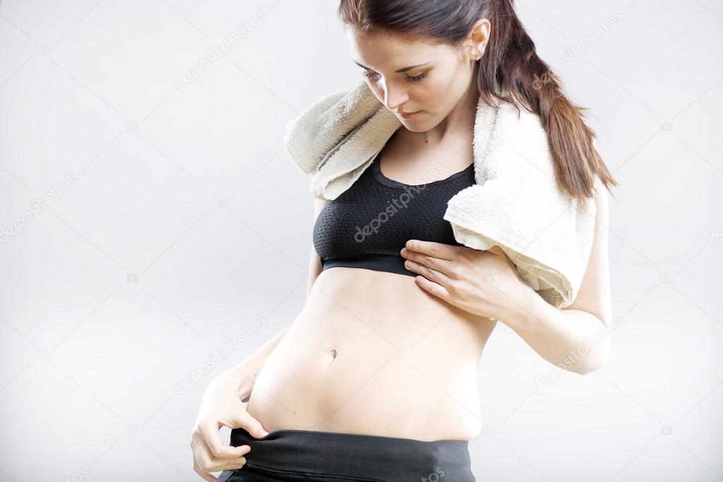 Woman looking at her flat stomach after training