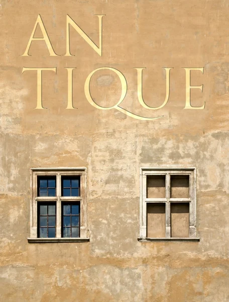 Antique word on old building wall — Stock Photo, Image