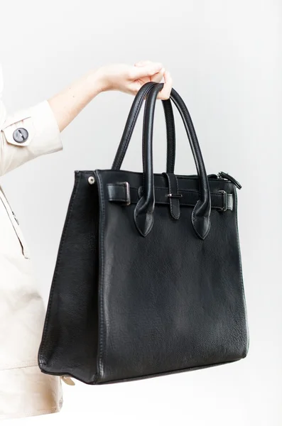 Elegant woman holding on finger black bag, closeup — Stock Photo, Image