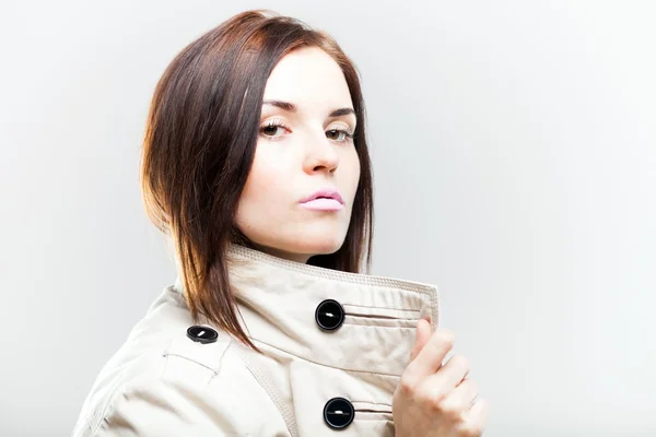 Elegante junge Frau im weißen Mantel — Stockfoto