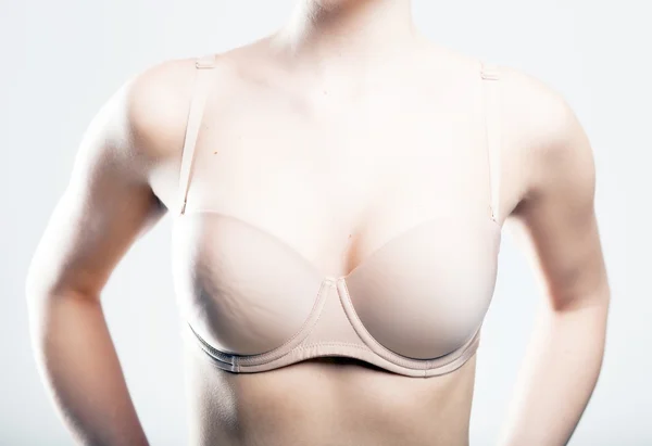 Huid-gekleurd beha, borst van jonge vrouw — Stockfoto