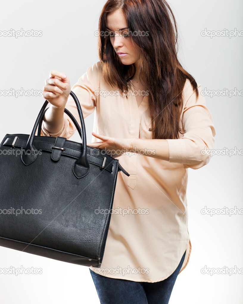 Elegant young woman looking in her purse