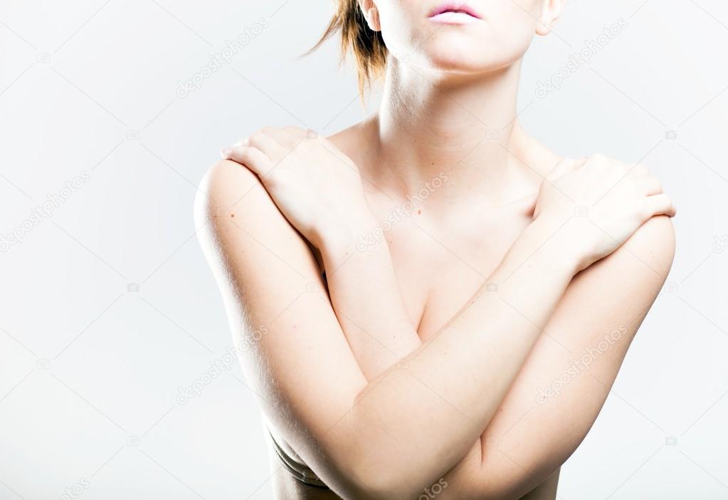 Woman covering her breasts arms