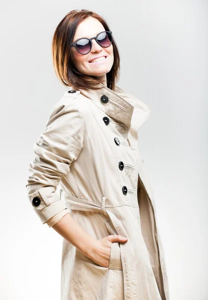 Smiling fashionable woman in coat with sunglasses — Stock Photo, Image