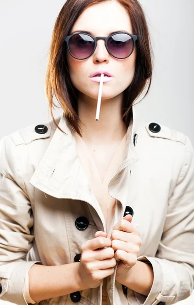 Elegant woman in white coat with sunglasses and cigarette — Stock Photo, Image