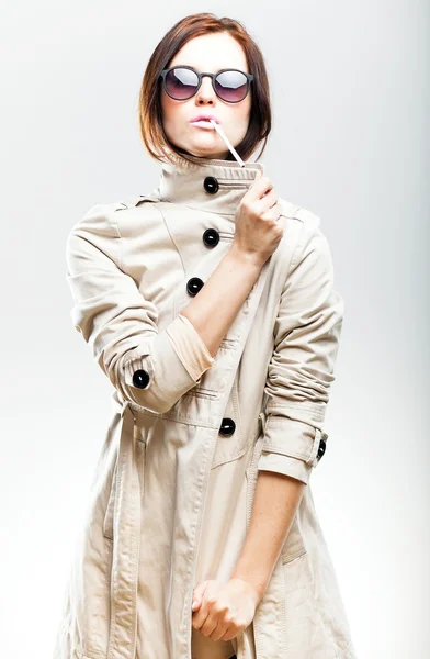 Femme à la mode en manteau et lunettes de soleil avec cigarette — Photo