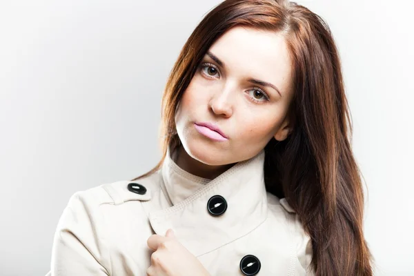 Modieuze jonge vrouw in witte jas — Stockfoto