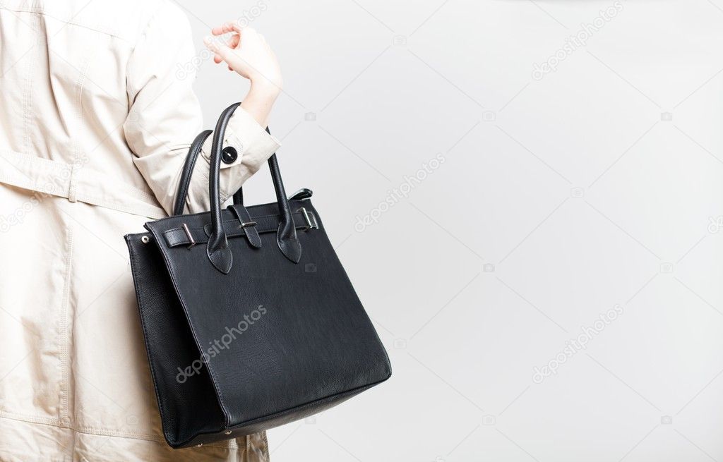 Fashionable woman with black bag, back view