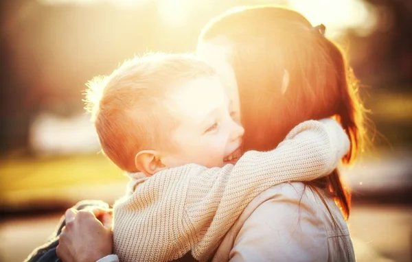 Moeder haar kind knuffelen in het park — Stockfoto