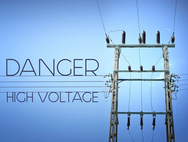Danger high voltage sign and tower — Stock Photo, Image