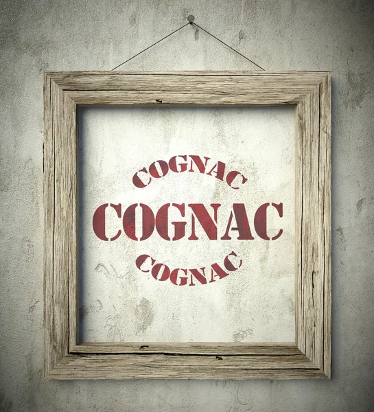 Cognac emblema na velha moldura de madeira na parede — Fotografia de Stock