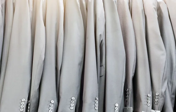 Row of elegant suits jacket on hangers, apparel store — Stock Photo, Image