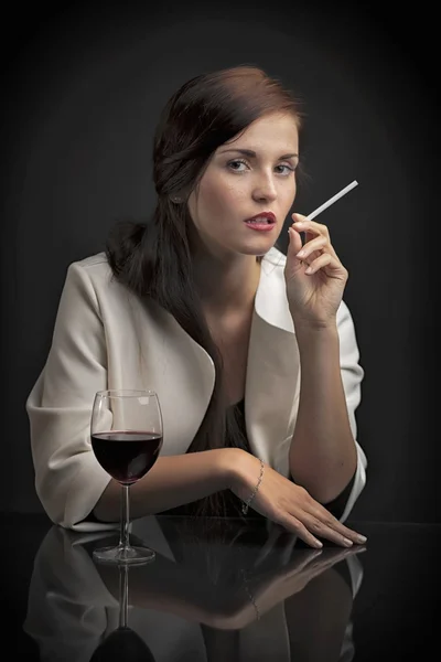 Porträtt av kvinna med glas vin och cigarett — Stockfoto