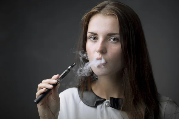 Elegant woman smoking e-cigarette with smoke — Stock Photo, Image