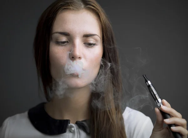 Elegant woman smoking e-cigarette with smoke — Stock Photo, Image