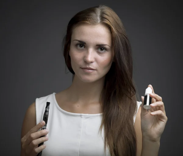 E-sigara ve sıvı şişe tutan kadın — Stok fotoğraf