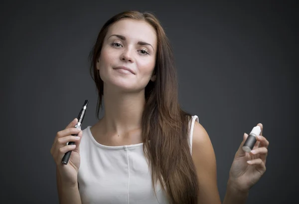 Woman holding e-cigarette and bottle of liquid — Stock Photo, Image