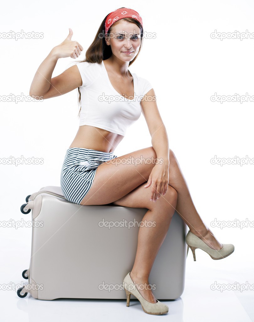 Woman with suitcase giving thumbs up sign