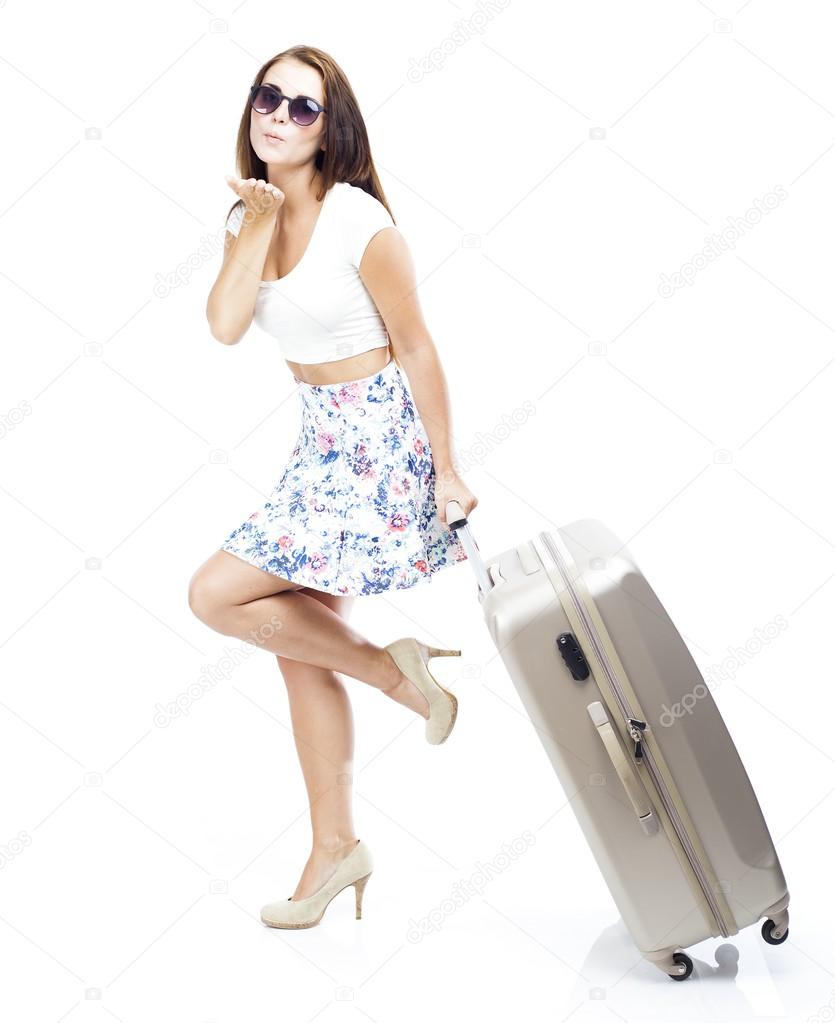 Tourist woman with suitcase sending kiss isolated