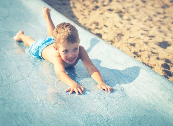 Child on water slide at aquapark, summer holiday — Stock Photo, Image