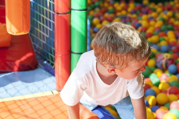 カラフルなボール遊び場で遊んでいる小さな少年 — ストック写真