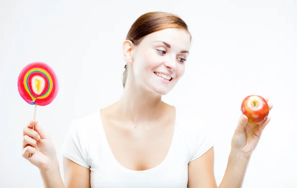 Mujer eligiendo entre dulces y frutas — Foto de Stock