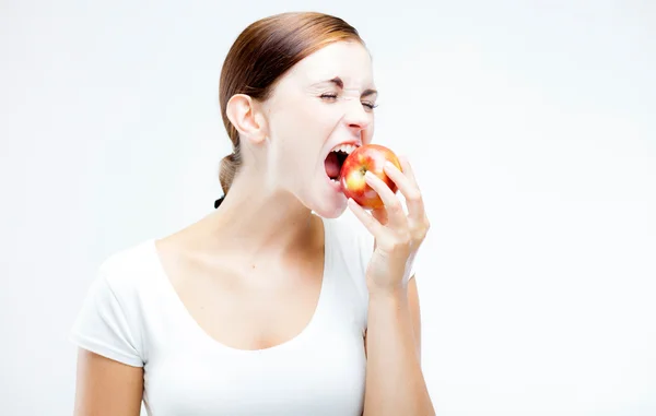 Kobieta trzyma i gryzienie czerwone jabłko, zdrowe zęby — Zdjęcie stockowe