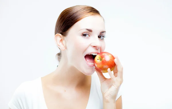 Mujer sosteniendo y mordiendo manzana roja, Dientes sanos — Foto de Stock