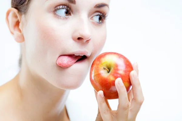 Kvinnan håller och äta rött äpple — Stockfoto
