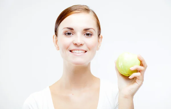 Mujer sonriente sosteniendo y comiendo manzana verde — Foto de Stock