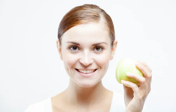 Mujer sonriente sosteniendo y comiendo manzana verde —  Fotos de Stock