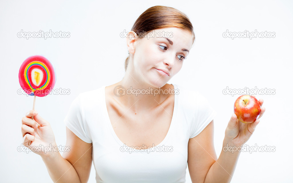 Woman choosing between sweets and fruits