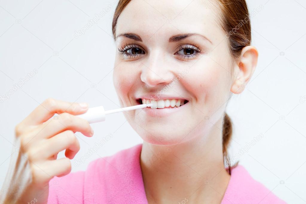 Teeth whitening, woman holding brush
