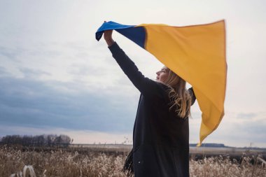 Rusya 'nın Ukrayna' ya karşı savaşı. Yanık bir buğday tarlasında bayrak sallayarak koşan genç, güzel bir vatansever kız. Bağımsız bir ülkenin insanlarının karlı duygusal tablosu, acısı ve umutsuzluğu.