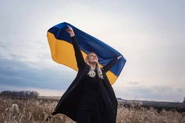 Rusya 'nın Ukrayna' ya karşı savaşı. Yanık bir buğday tarlasında bayrak sallayarak koşan genç, güzel bir vatansever kız. Bağımsız bir ülkenin insanlarının karlı duygusal tablosu, acısı ve umutsuzluğu.