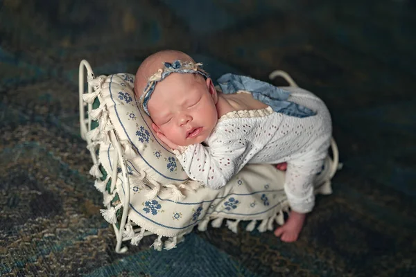 Little newborn Ukrainian girl sleeps peacefully on the bed. National embroidered clothes