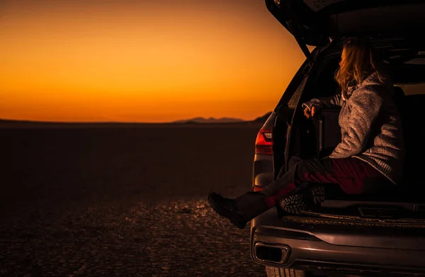 40多岁的白人妇女从她的运动型实用汽车货舱享受加州莫哈韦沙漠日落的美景 旅行和娱乐主题 — 图库照片
