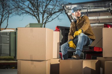 40 'lı yaşlarda Kafkas kuryesi, kargo kutularıyla kamyonetinde kısa bir mola alıyor. Kargo Boşaltılıyor.