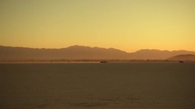 Gün batımında Güney Kaliforniya 'daki Düz Göl yatağında tüm arazi araçlarının ATV' leri hız yapıyor. OHV off-Highway Araç Alanı Sürülüyor.