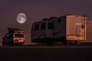 Full Moon Night in a RV Park. Modern Camper Van Motorhome and Travel Trailer. Recreational Vehicles and Camping Theme.
