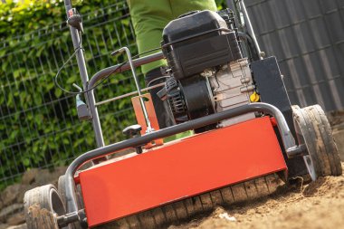 Lawn Aeration and Preparing Ground For Grass Turfs Installation. Powerful Garden Equipment Close Up.