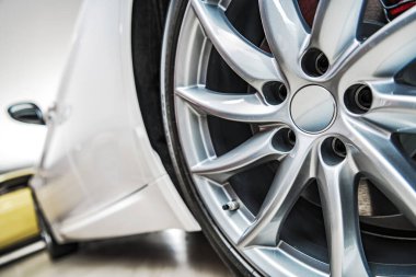 Vehicles Sales Industry. Modern Luxury Car on Display in a Dealership Showroom. Alloy Wheel Close Up. 