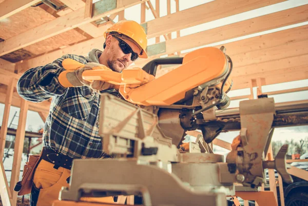 30代の白人建設請負業者労働者が工事区域で木材ビームの破片をトリミング — ストック写真