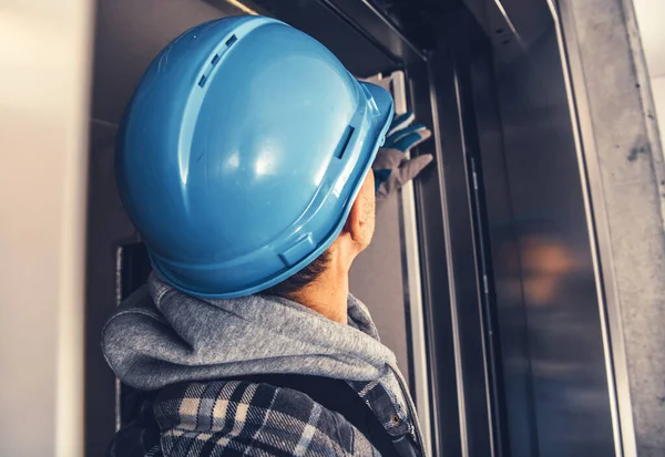 Caucasian Elevator Technician Wearing Blue Hard Hat Taking Close Look — Stock Photo, Image